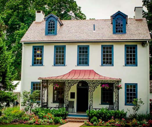 Residential home exterior painted white with blue window frames