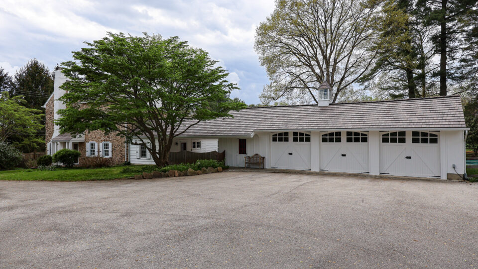 Wide shot of stone home with professionally painted garage doors