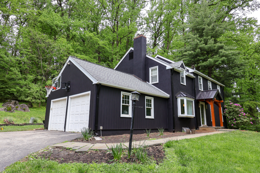 Front view of a home painted in Sherwin Williams Black Magic with crisp white trim.