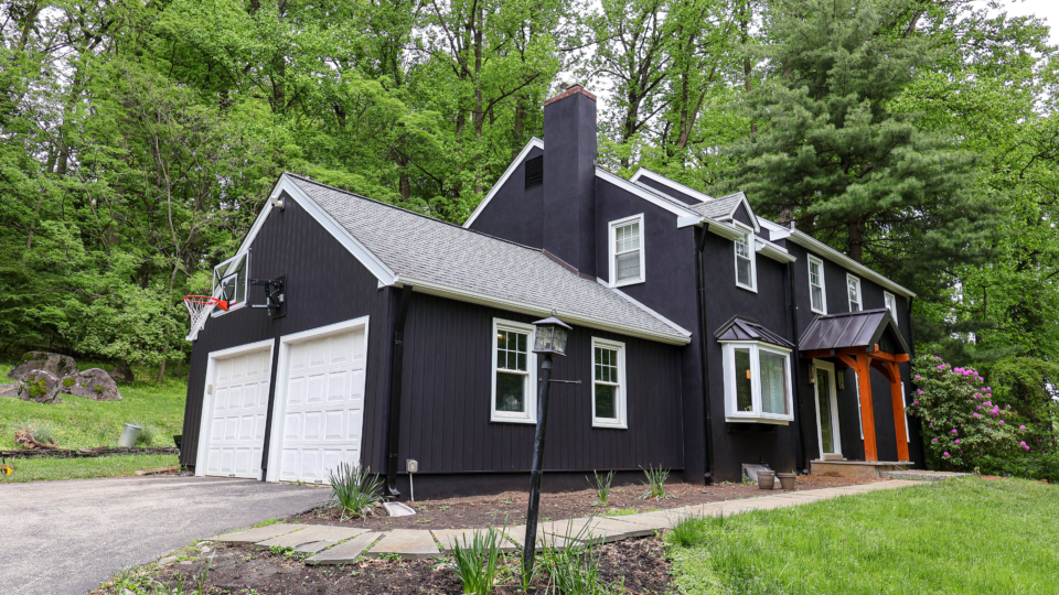 Front view of a home painted in Sherwin Williams Black Magic with crisp white trim.
